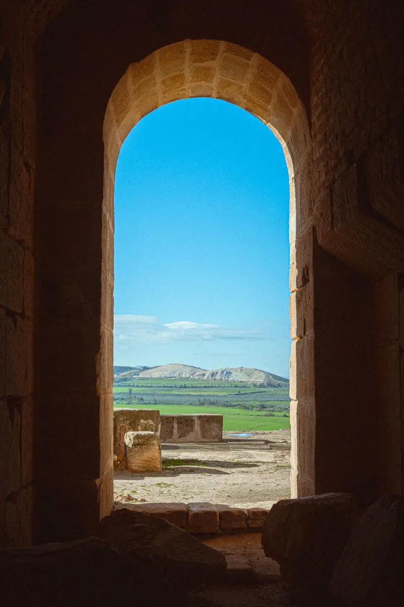 Vista del campo a través de un arco de piedra